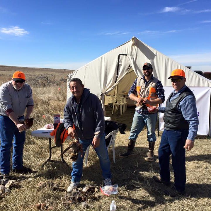 Group of hunters pose in front of their tent