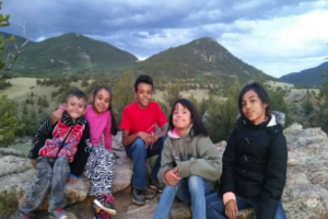 Group of children posing on rocks with mountains in background